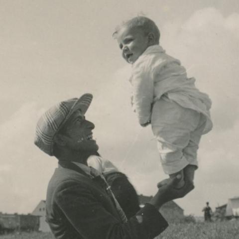 Foto eines Mannes, der ein Kind auf den Händen hält.