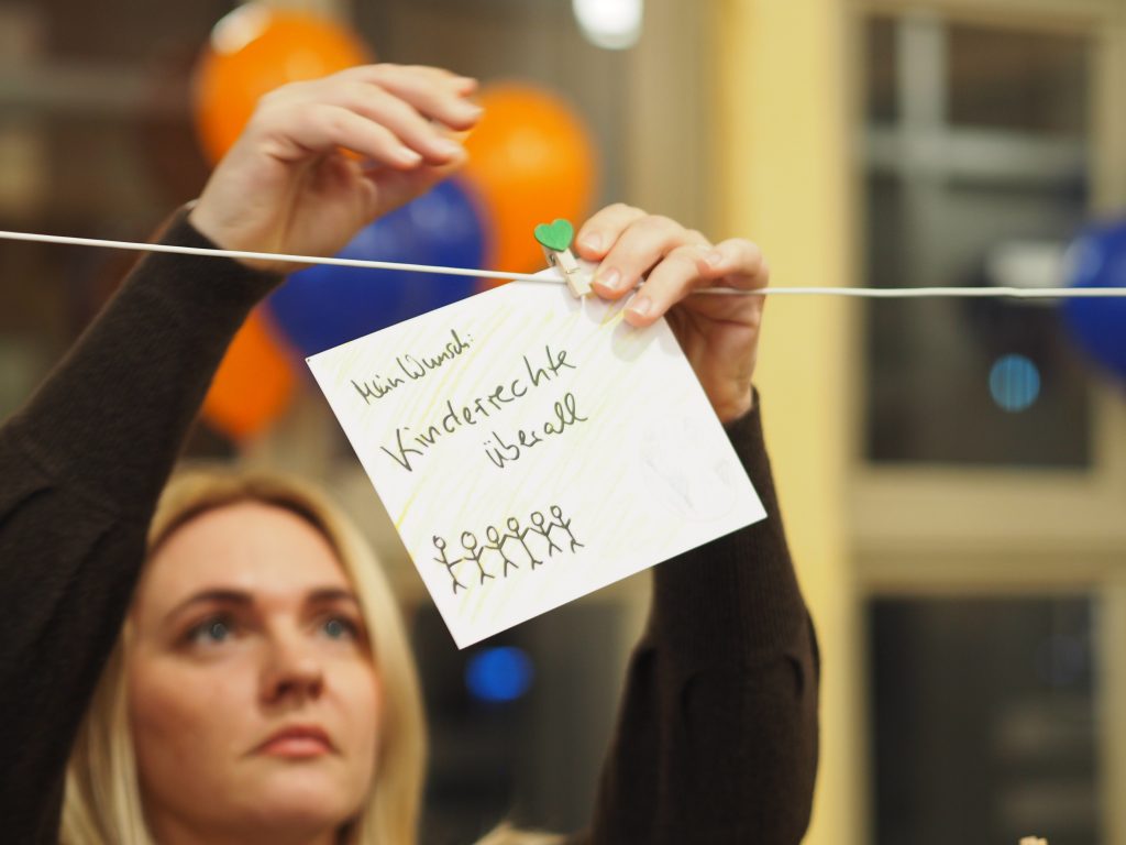 Frau hängt Postkarte an Leine